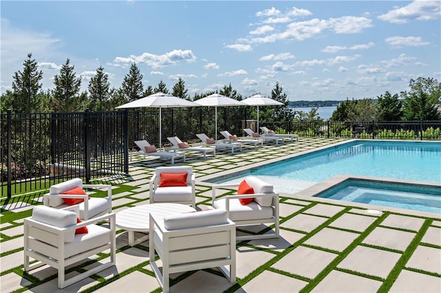 view of swimming pool featuring an in ground hot tub, a water view, and a patio