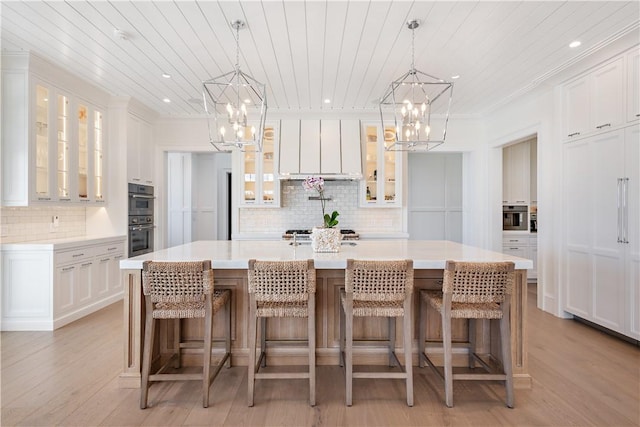 kitchen featuring a breakfast bar, white cabinetry, and a spacious island