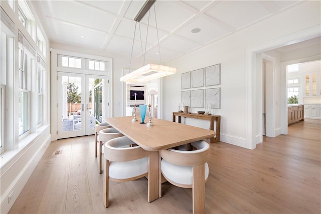 dining area featuring french doors, light wood-type flooring, and coffered ceiling