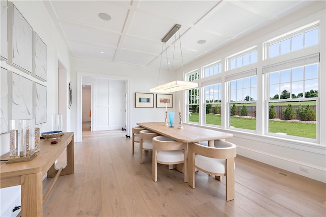 dining space with beam ceiling, light hardwood / wood-style flooring, and coffered ceiling