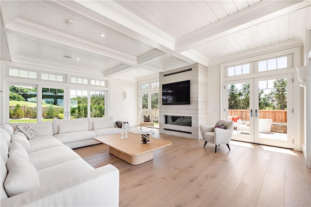 living room with french doors, light wood-type flooring, a healthy amount of sunlight, beam ceiling, and a fireplace