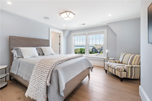 bedroom with light hardwood / wood-style floors and ornamental molding