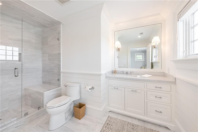 bathroom with an enclosed shower, vanity, toilet, and ornamental molding