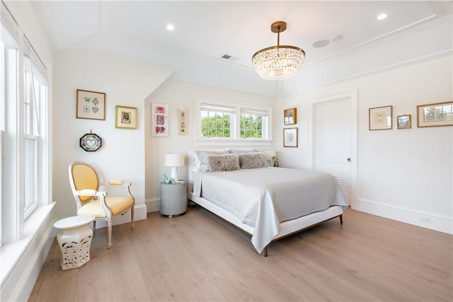 bedroom featuring a chandelier and light hardwood / wood-style flooring