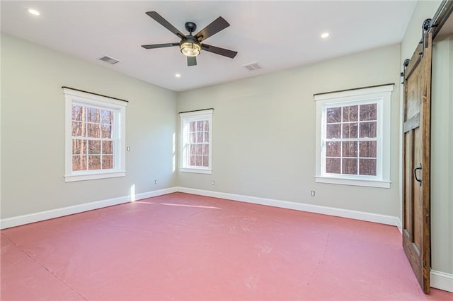 empty room with ceiling fan and a barn door