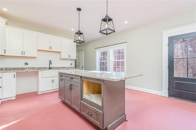 kitchen with white cabinetry, a kitchen island, and hanging light fixtures