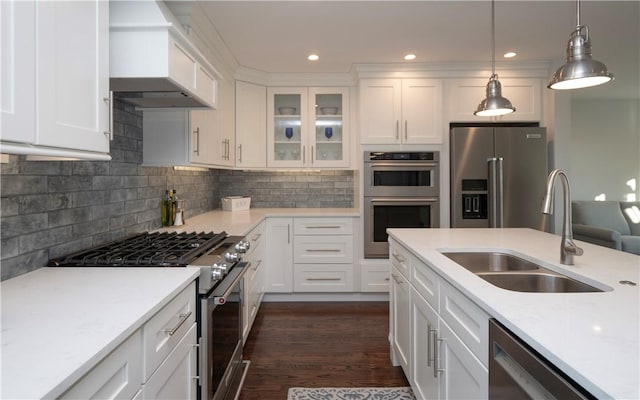 kitchen featuring pendant lighting, sink, tasteful backsplash, white cabinetry, and stainless steel appliances