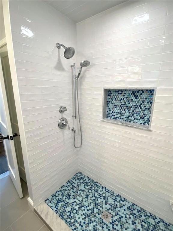 bathroom featuring tiled shower and tile patterned flooring