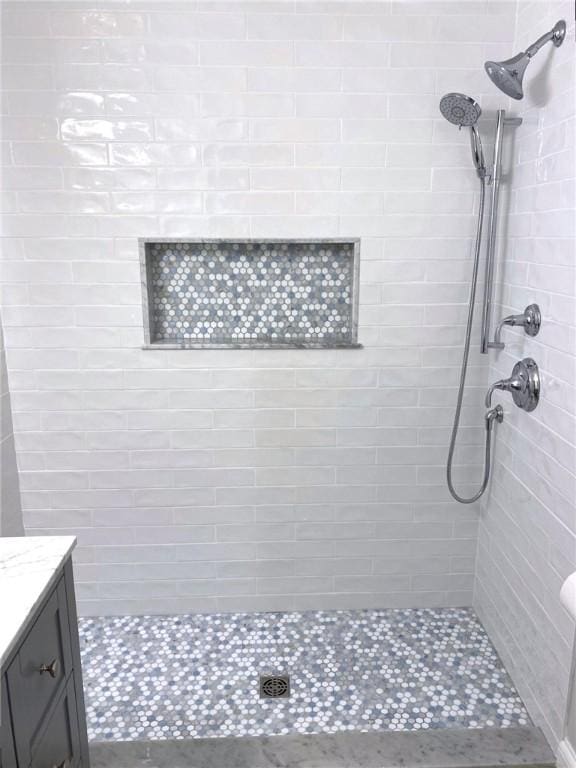 bathroom featuring vanity and tiled shower