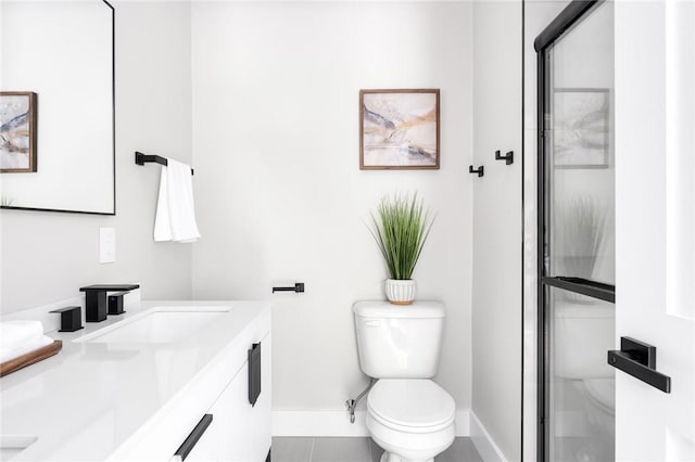 bathroom featuring tile patterned flooring, vanity, toilet, and an enclosed shower