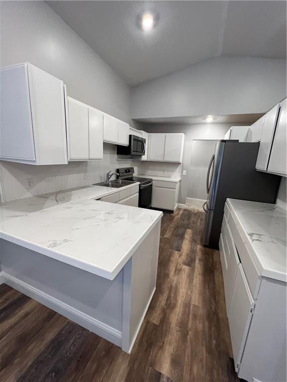 kitchen with kitchen peninsula, white cabinets, stainless steel appliances, and vaulted ceiling