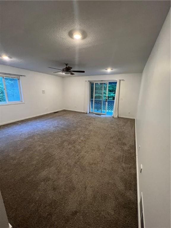 carpeted spare room featuring ceiling fan and a textured ceiling