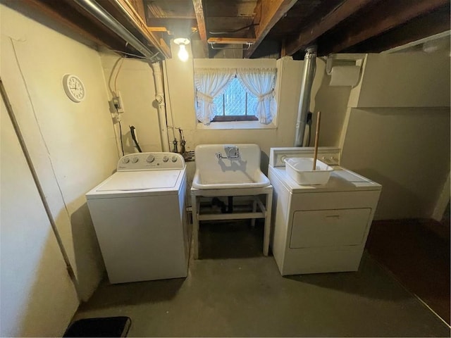 clothes washing area featuring separate washer and dryer and sink