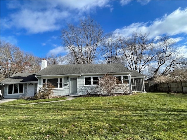 view of front of home with a front yard and a sunroom