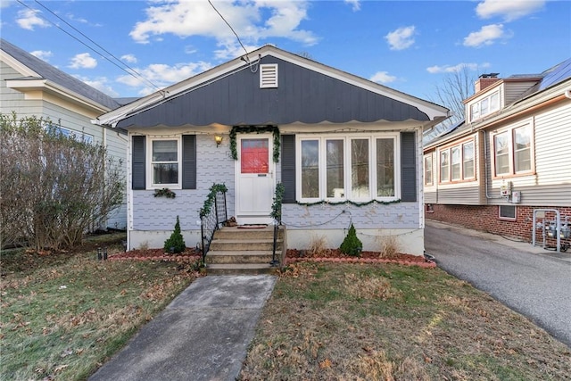 bungalow-style house with a front lawn