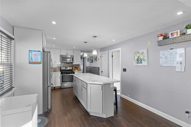 kitchen with white cabinetry, a center island, stainless steel appliances, and decorative light fixtures