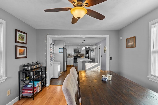 dining space featuring light wood-type flooring and ceiling fan