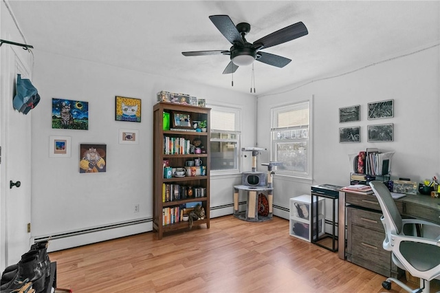 home office featuring baseboard heating, ceiling fan, and light wood-type flooring