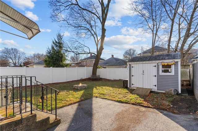 view of yard featuring a shed and an outdoor fire pit