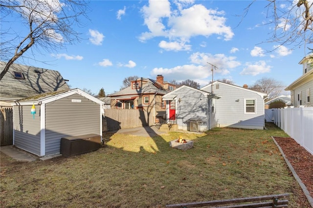 rear view of property featuring a yard and a shed