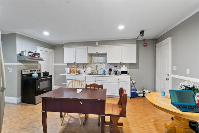 kitchen with white cabinetry, electric range, sink, decorative backsplash, and light wood-type flooring