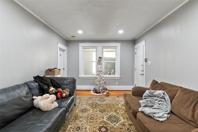 living room with baseboard heating, ornamental molding, a textured ceiling, and hardwood / wood-style flooring