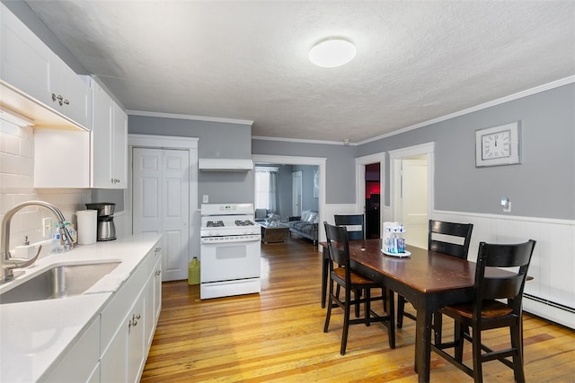 kitchen with white range oven, sink, white cabinets, and light wood-type flooring