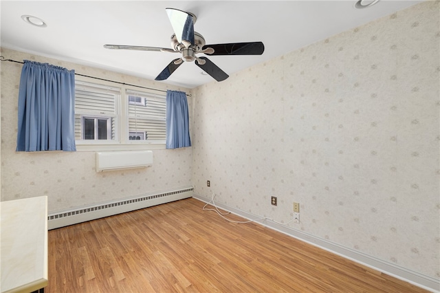 empty room featuring a baseboard radiator, a wall mounted air conditioner, and light hardwood / wood-style floors