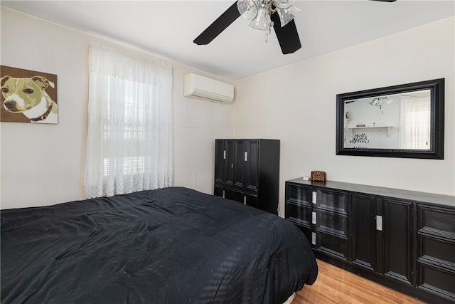 bedroom featuring a wall mounted air conditioner, ceiling fan, and light hardwood / wood-style flooring