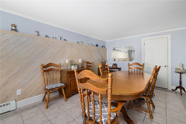 tiled dining space with baseboard heating and crown molding