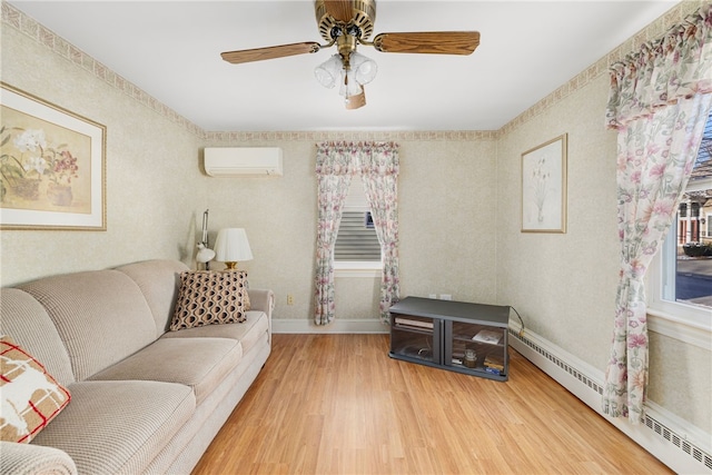 living room featuring baseboard heating, ceiling fan, wood-type flooring, and a wall mounted air conditioner