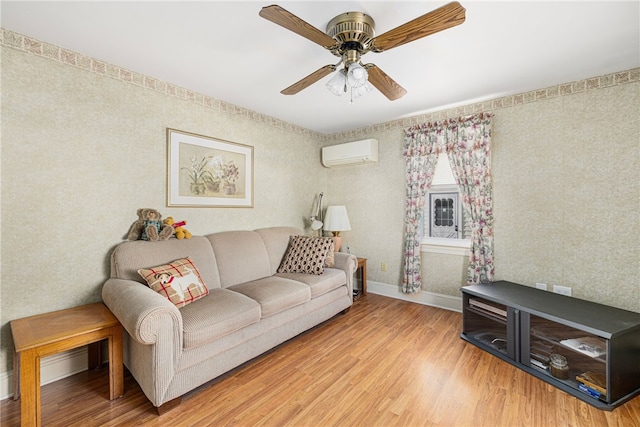 living room featuring an AC wall unit, ceiling fan, and light wood-type flooring