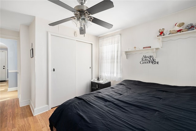 bedroom with light hardwood / wood-style flooring, a closet, and ceiling fan