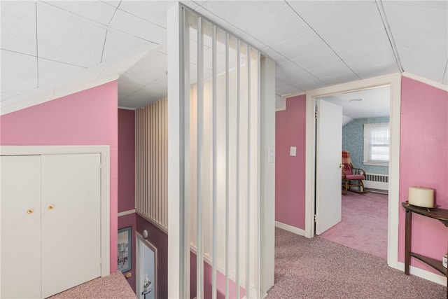 hallway with radiator, carpet, and vaulted ceiling