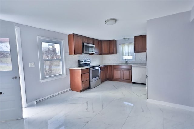 kitchen featuring baseboard heating, sink, appliances with stainless steel finishes, and tasteful backsplash