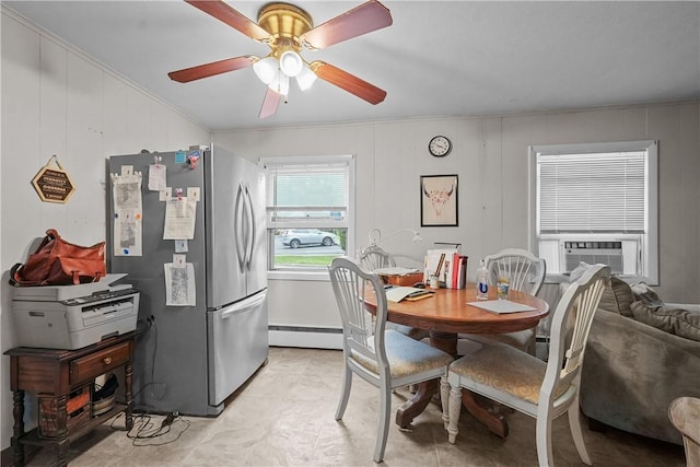 dining area featuring ceiling fan, wooden walls, cooling unit, and a baseboard radiator