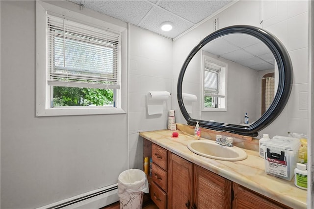 bathroom with a paneled ceiling, vanity, and a baseboard radiator