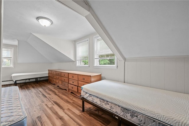 bedroom featuring a baseboard radiator, light hardwood / wood-style floors, and vaulted ceiling