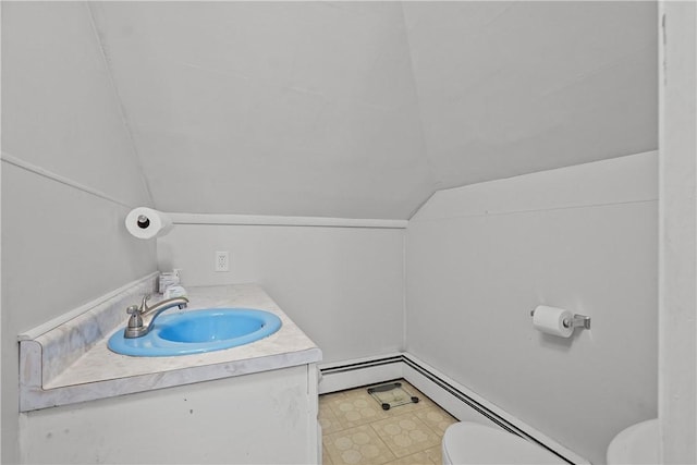 bathroom with vanity, toilet, baseboard heating, and vaulted ceiling