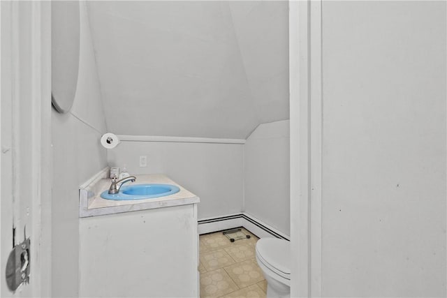 bathroom featuring vanity, toilet, lofted ceiling, and a baseboard radiator