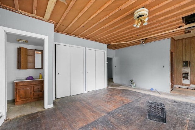 unfurnished bedroom featuring dark hardwood / wood-style floors and two closets