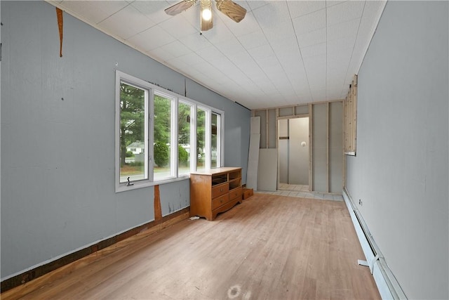 unfurnished room featuring ceiling fan, light hardwood / wood-style floors, and a baseboard heating unit