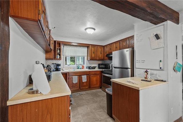 kitchen featuring tasteful backsplash, sink, ornamental molding, and appliances with stainless steel finishes