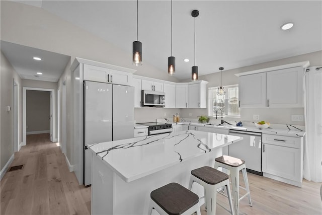 kitchen featuring pendant lighting, a center island, white cabinetry, and stainless steel appliances