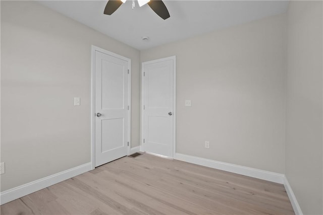 spare room with light wood-type flooring and ceiling fan