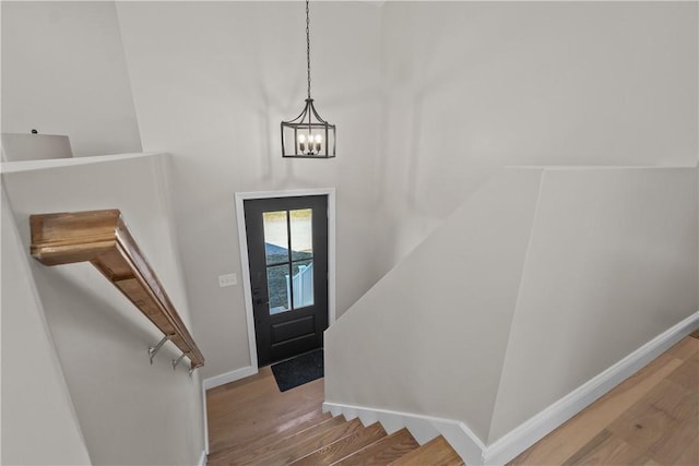 foyer featuring wood-type flooring and an inviting chandelier