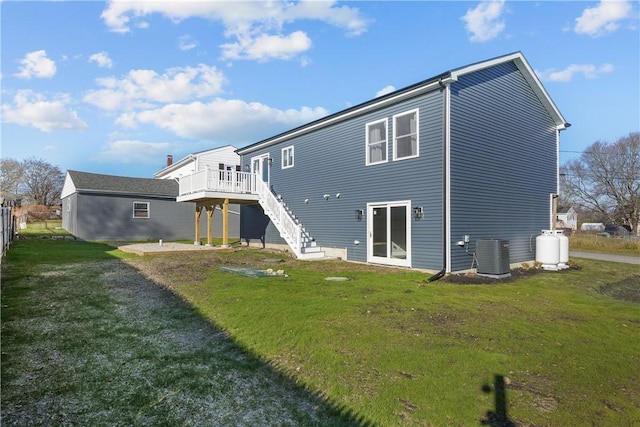 rear view of property featuring a yard, a wooden deck, and central air condition unit