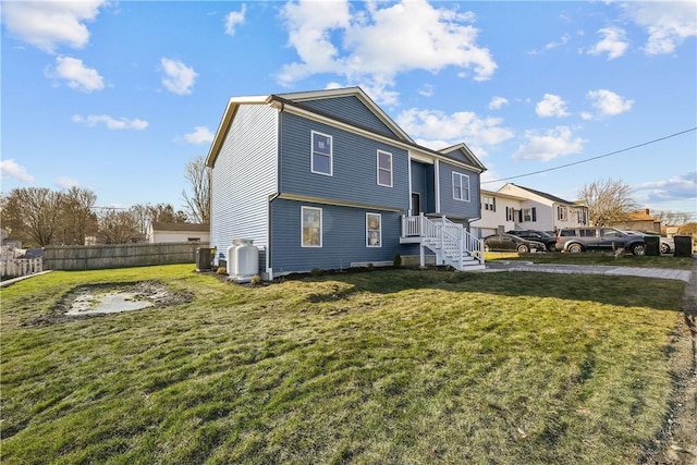 exterior space with central AC and a lawn