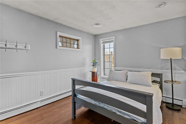 bedroom featuring hardwood / wood-style flooring and baseboard heating