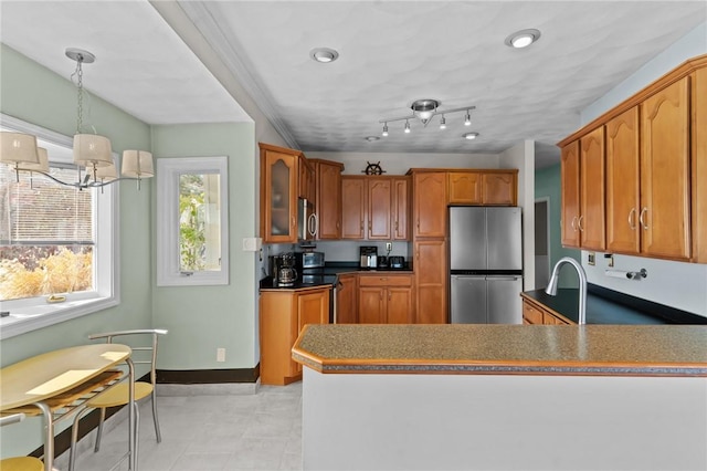 kitchen featuring a chandelier, appliances with stainless steel finishes, decorative light fixtures, and a healthy amount of sunlight